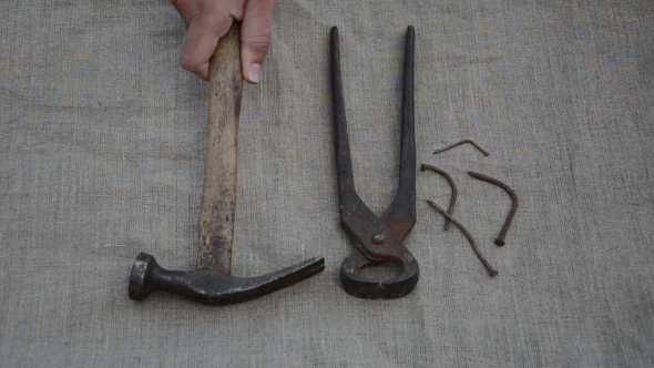 Rusty Tongs, Hammer Tool And Bent Nails Fall On Linen Background