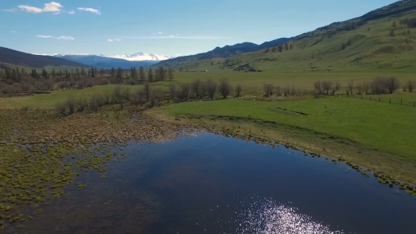 Aerial Of Flying Over Trees To Mountain Lake alt