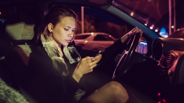 Beautiful Girl With a Phone In The Car