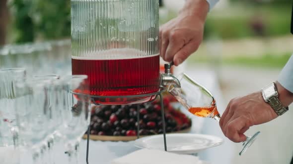 Waiter Fills Up a Glass with Some Rose Wine From a Decanter alt