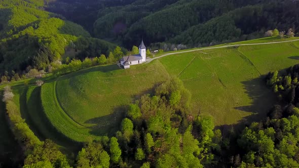 drone footage sunset at Church of St. Primus and Felician, Jamnik, Slovenia alt