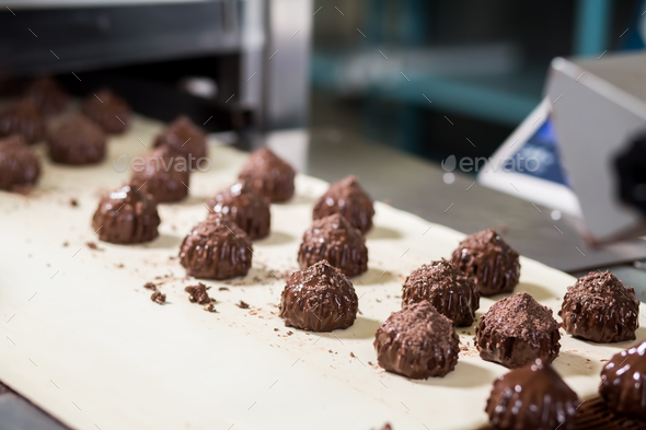 Candies with shavings on conveyor. - Stock Photo - Images