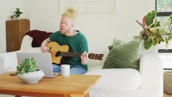 Albino african american man with dreadlocks playing guitars and singing alt