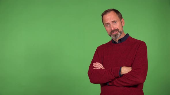 A Middleaged Handsome Caucasian Man Nods at the Camera with a Smile  Green Screen Background