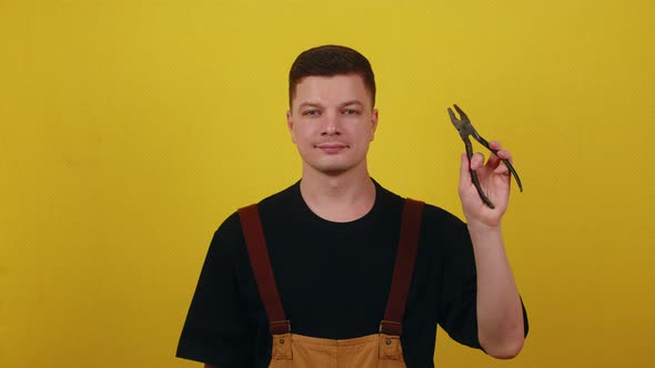 Electrician or Handyman Holds Tools for Working with Electricity in His Hands alt