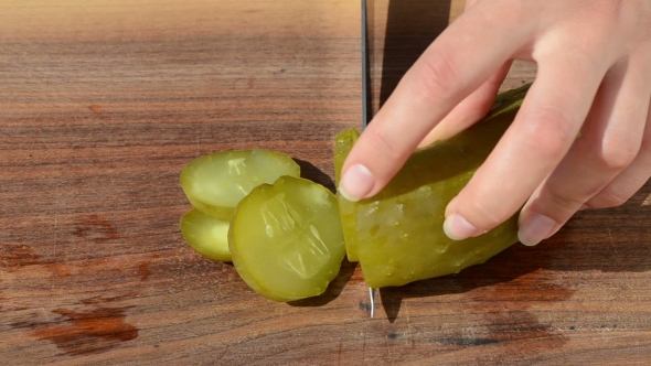 Woman Hand Slice Pickled Cucumber With Knife