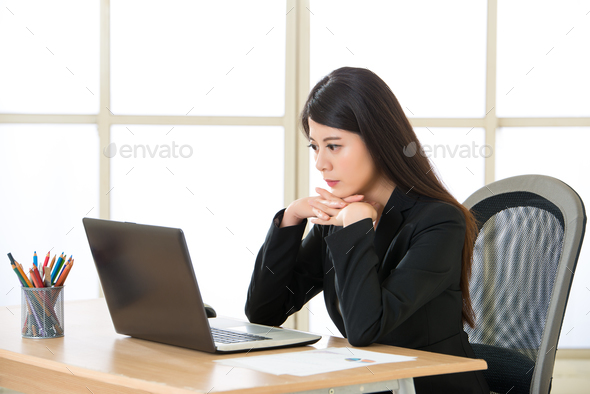 Young Asian businesswoman thinking and Staring at Computer Scree