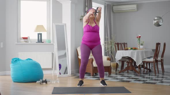 Wide Shot of Hilarious Obese Woman Grimacing Stretching Resistance Band Training at Home alt