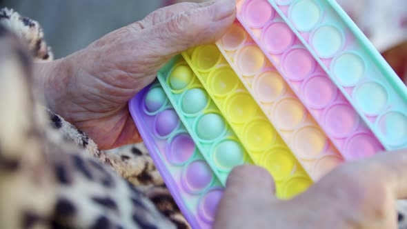 Old Wrinkled Hands of an Elderly Man Play Pop It in the Open Air Natural Sanctification alt