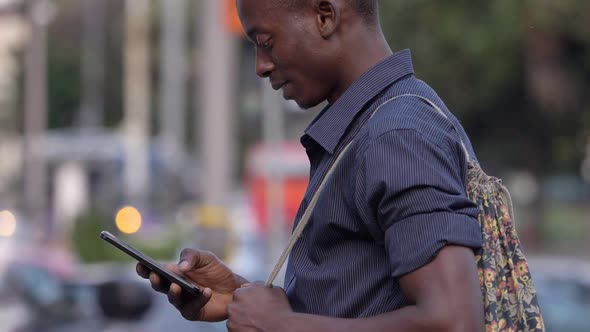 carefree black ma typing on smartphone in the street- profile- slow motion alt