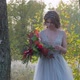A Young Woman Dressed in a Gray Wedding Dress Celebrates Her Wedding, She Has Flowers in Her Hand - VideoHive Item for Sale