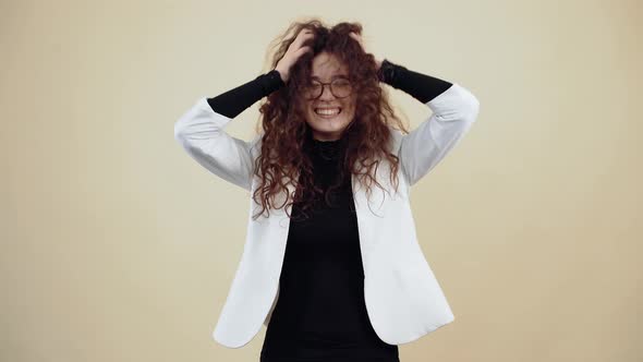 Victorious Young Woman with Curly Hair Shakes Her Hair with Her Hands and Her Mouth is Watery alt