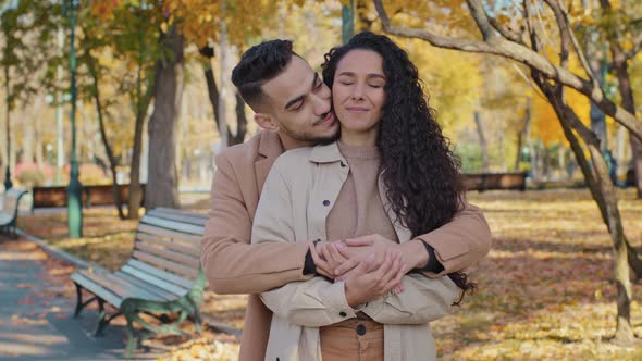 Hispanic Young Couple Hugging Standing in Autumn Park Happy Man and Woman Smiling Enjoying Date Guy alt