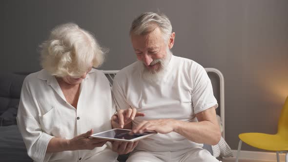 Happy Elderly Caucasian Man and Woman Play Online Games Look at Screen