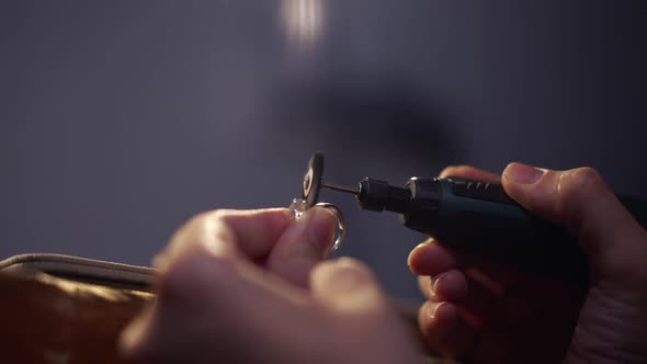 Closeup Silver Ring with Gemstone in Female Hands Polishing Jewellery alt
