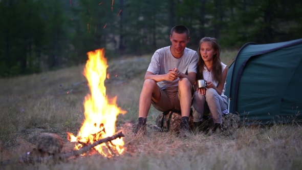 Couple At The Camping With Campfire