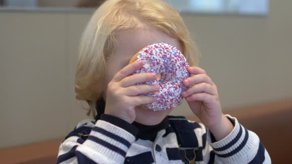 Boy Playing With a Glazed Donut.