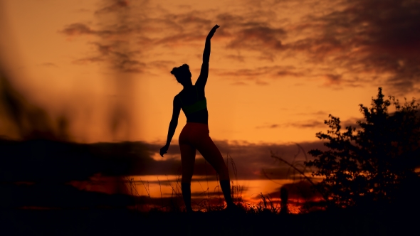 Slender Young Woman Doing Fitness Exercises In The Warm-up At Sunset. Flexible Shape alt