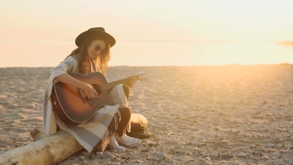 Beautiful Young Woman Playing Guitar On Beach