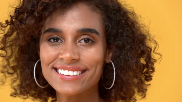 Closed up headshot of beautiful pretty curly hair woman looking at camera with smiling face