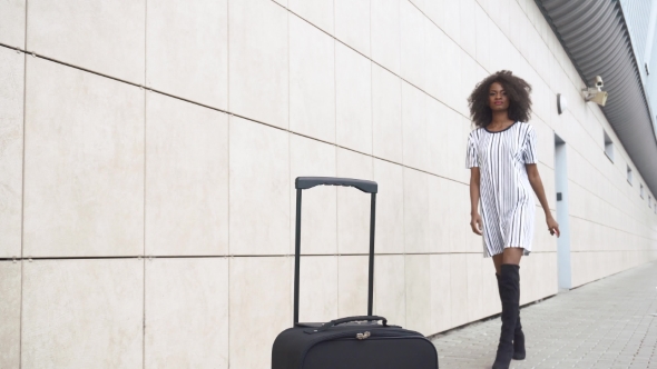 Attractive African American Businesswoman Takes Her Luggage And Goes For Boarding To The Plane