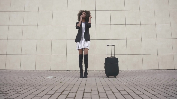 Elegant Slim African American Woman With Luggage Talking By Phone At The Airport. White Textured