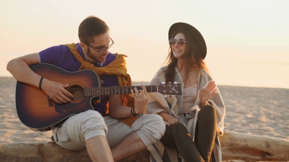 Cute Hispanic Couple  Playing Guitar  Serenading On Beach In 