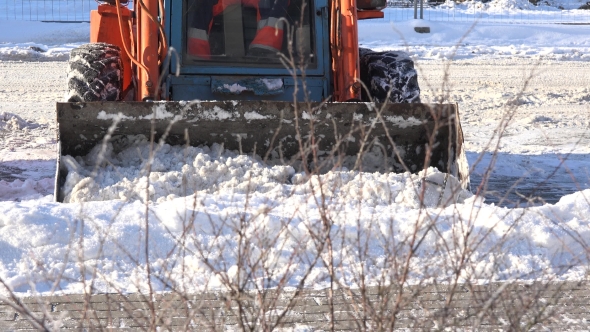 Mini Excavator Working On Street, Cleaning Snow.
