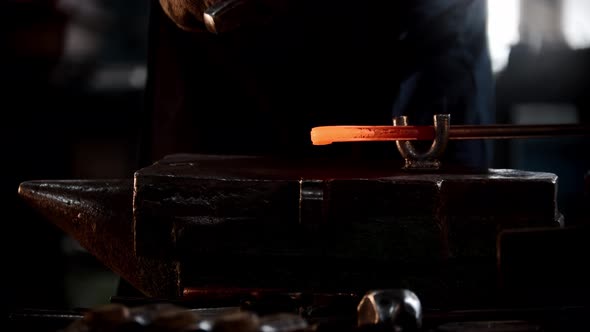Blacksmith Workshop  a Man Bends a Piece of Metal with Hitting It with a Hammer alt