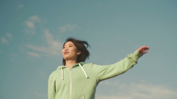 Sensual Young Asian Woman With Short Hair Stretching Outdoor. Blue Clean Sky Background