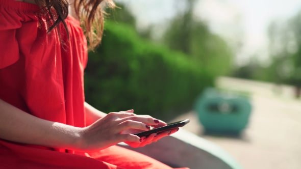 Woman in Red Dress Holding a Phone With App Mobile Wallet alt