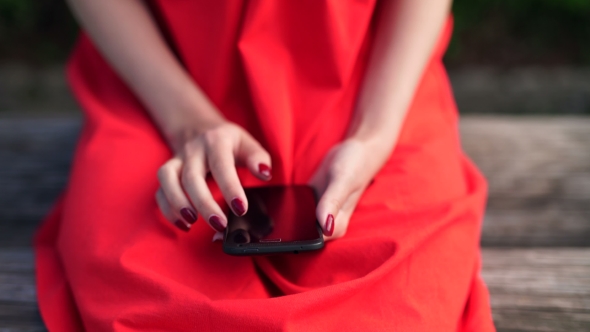 Woman In Red Dress Holding a Phone With App Mobile Wallet alt