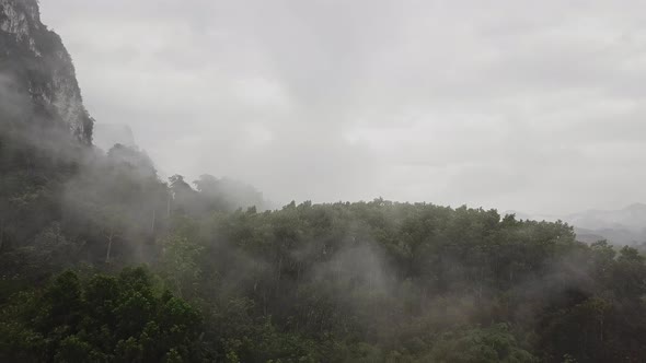 Flying Above Tropical Valley with Mist Clouds on a Rainy Day