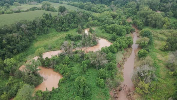 Aftermath of a storm in a midwest valley. Muddy creek water making it's own way through valley.