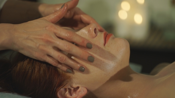 Pretty Young Woman Doing Facial Massage