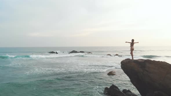 Woman on the Rock with Hands Up