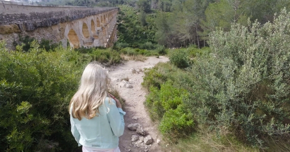 Tourist Girl Walk Near The Ancient Devil's Aqueduct