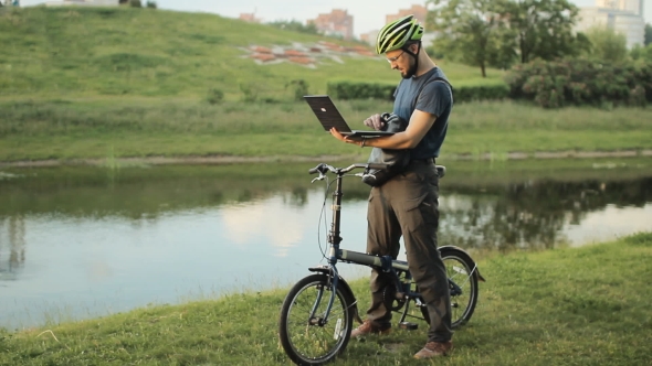 Man On Bicycle Working On Laptop
