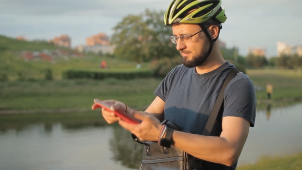 Man On Folding Bicycle With Tablet