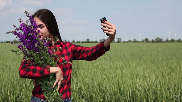 Young Woman Brunette With a Bouquet Of Wildflowers Makes Selfie.