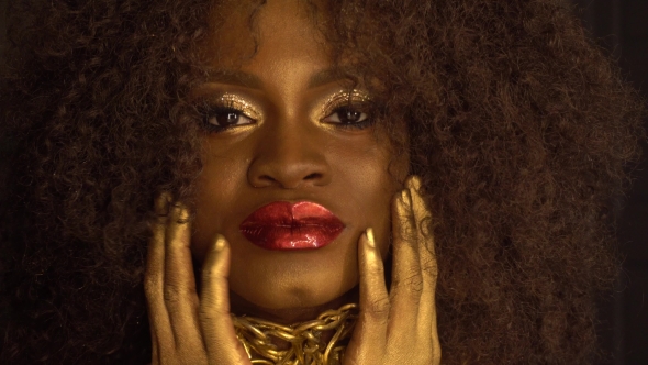 Surreal Portrait Of Young African American Female Model With Gold Glossy Makeup. Face Art.