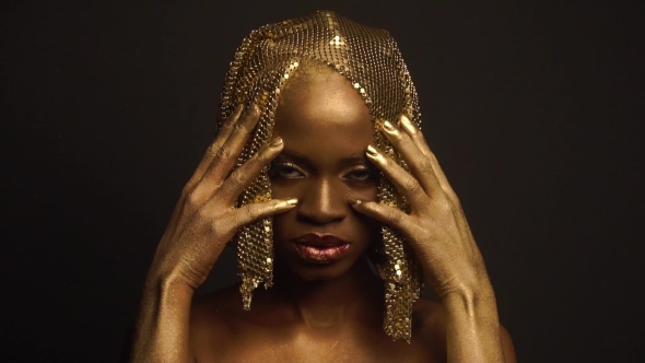 Enigmatic African American Female Model With Golden Glossy Makeup And Headwear