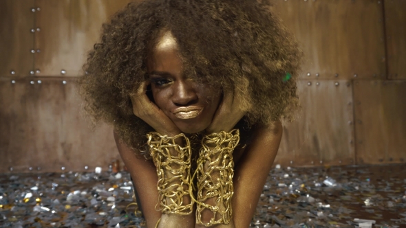 Creative Surreal Portrait Of Sexy African American Female Model With Gold Glossy Makeup