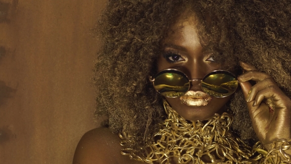African American Female Model In Massive Sunglasses With Bright Glitter Makeup