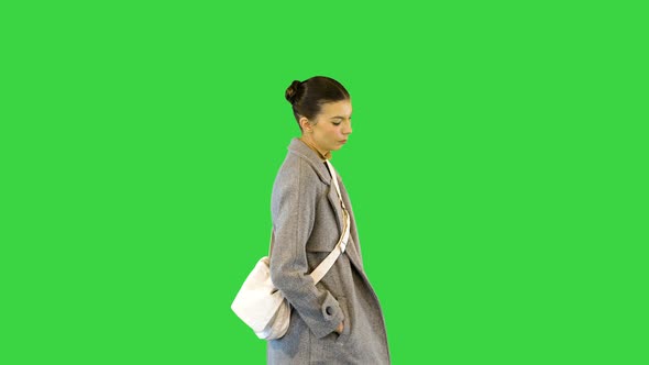 Young Woman in Smart Casual Clothes Walks Slowly on a Green Screen Chroma Key
