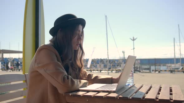 Romantic Woman Is Sitting Alone in Front of Laptop, View on Screen Outdoors alt