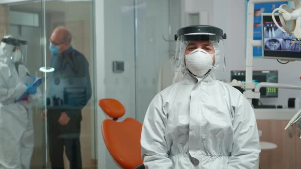 Dentist in Coverall Looking and Smiling at Camera alt