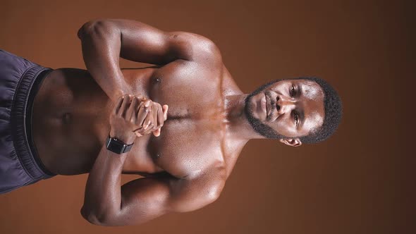 Closeup of a Darkskinned Athletic Man with a Perfect Abs on a Dark Background