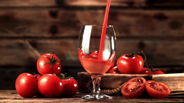 Super Slow Motion in the Glass on the Table Pours Tomato Juice alt