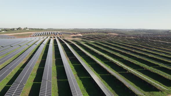 Rows of solar panels on commercial solar farm producing green energy; drone